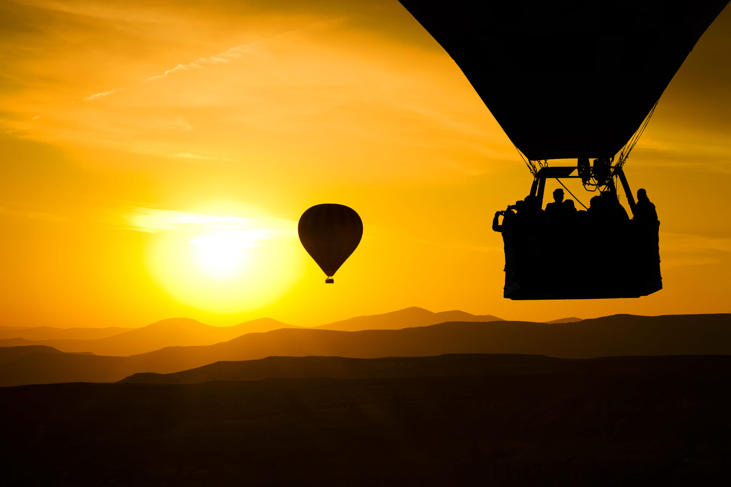 Hot balloon silhouette with sunrise sky background.